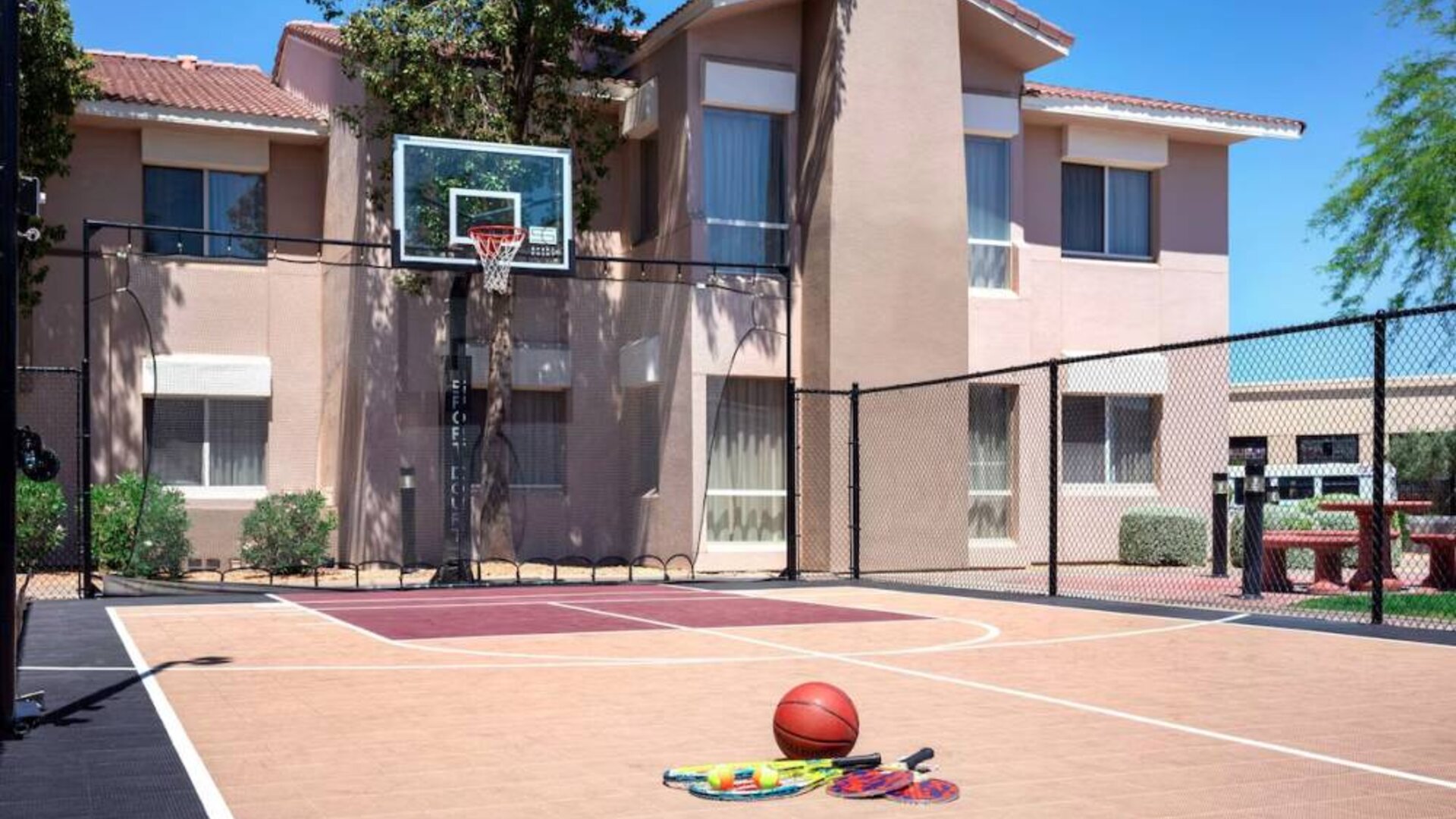 The hotel basketball court has fencing by the hoop, and can also be used for playing tennis.