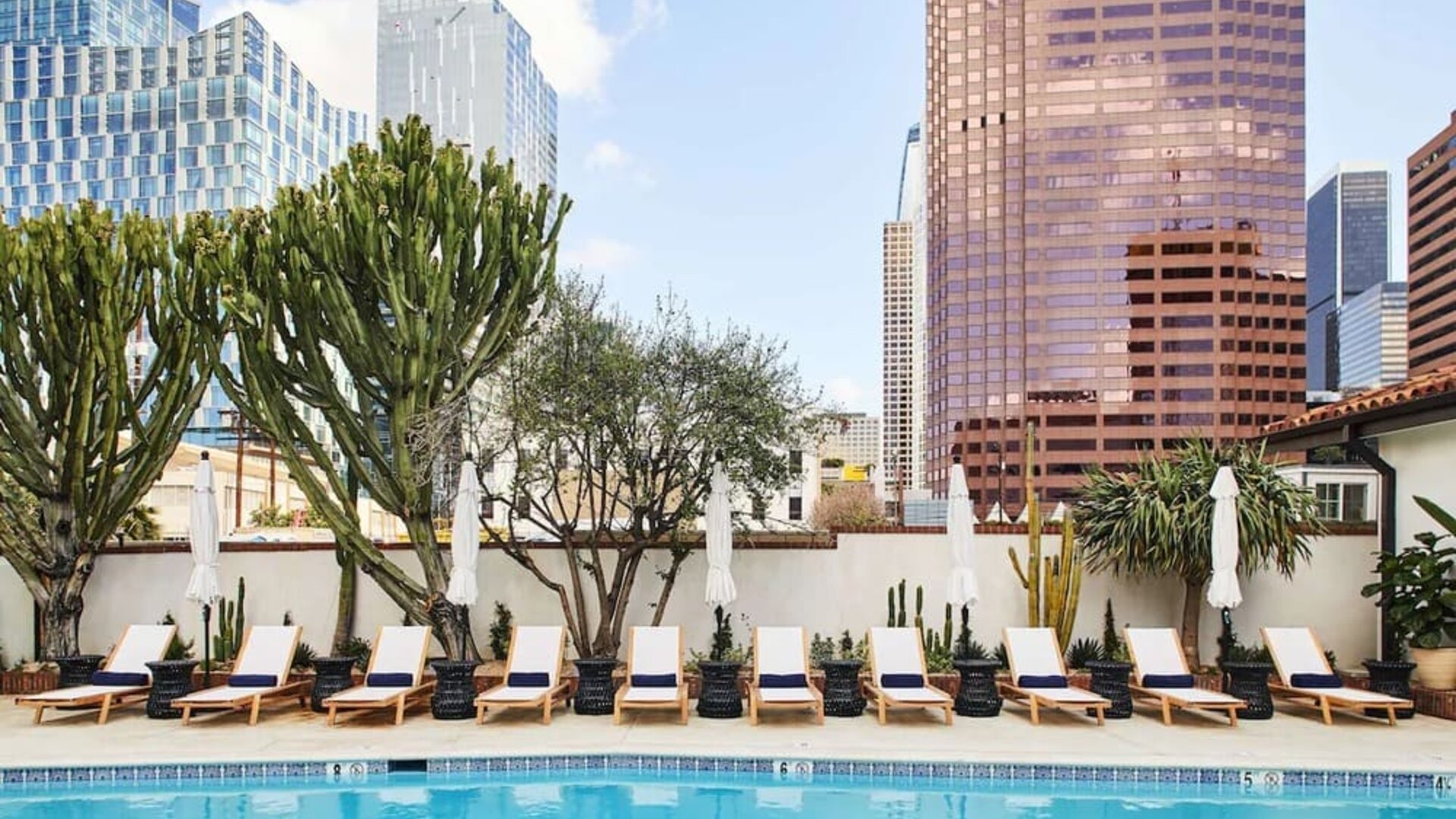Relaxing outdoor pool with pool chairs at Hotel Figueroa.