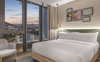 Delux king room with chair at Hilton Garden Inn Tbilisi Riverview.