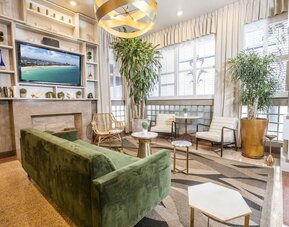 Lobby and lounge area with TV at Chesterfield Hotel & Suites.
