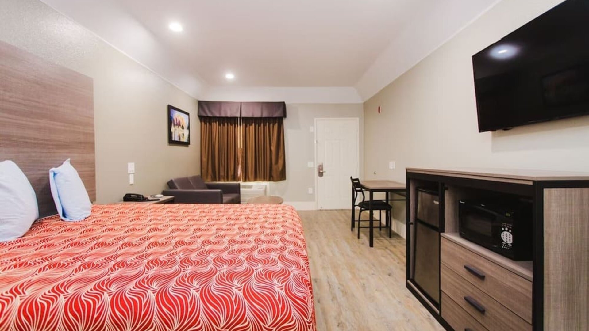 King bed with TV and work space at Palace Inn I-10 West & Beltway 8.