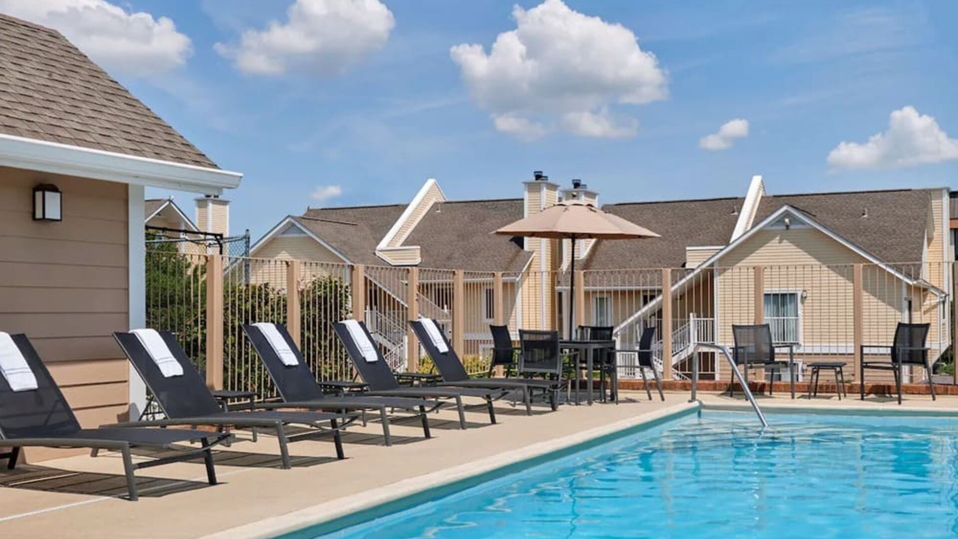 Outdoor pool with pool chairs at Sonesta ES Suites Cincinnati - Blue Ash.