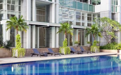 Hotel pool with pool chairs at Fraser Residence Sudirman Jakarta.