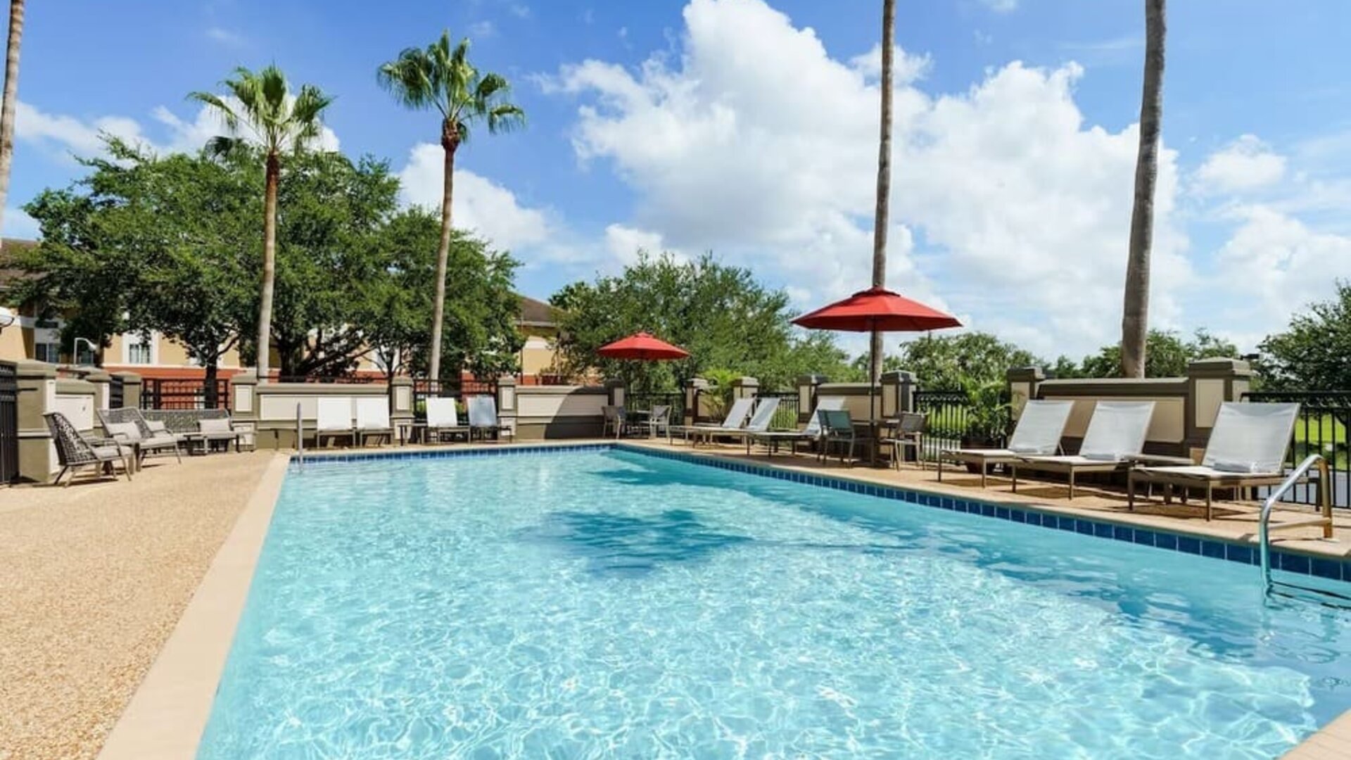 Outdoor pool with palm trees at Hyatt Place Orlando I-Drive.
