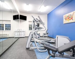 Fitness center at Coratel Inn & Suites By Jasper Rochester.