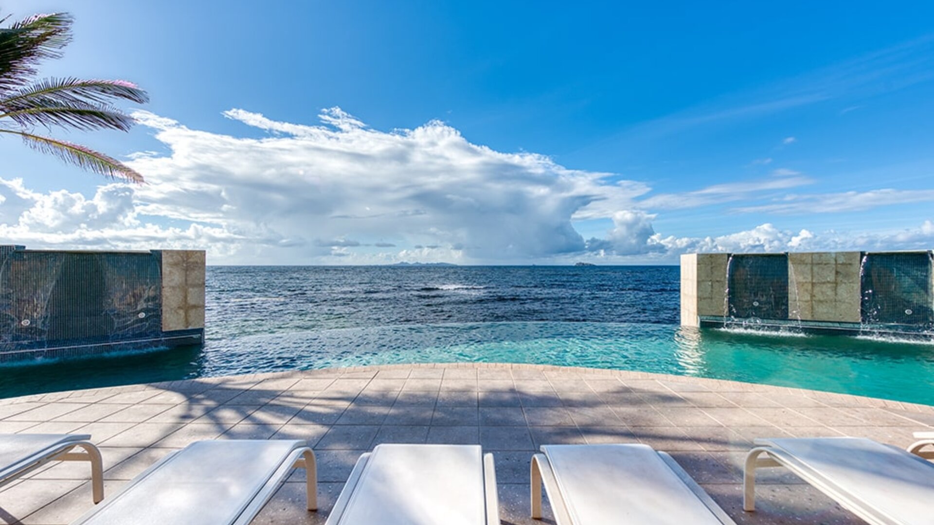 Chair deck relaxing view of Infinity Pool and Oyster Bay, at Oyster Bay Resort in St. Maarten. 