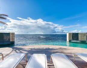 Chair deck relaxing view of Infinity Pool and Oyster Bay, at Oyster Bay Resort in St. Maarten. 