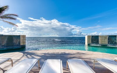 Chair deck relaxing view of Infinity Pool and Oyster Bay, at Oyster Bay Resort in St. Maarten. 