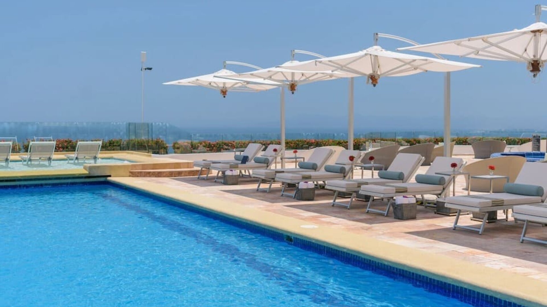 Outdoor pool with pool loungers at Grand Miramar All Luxury Suites & Residences.