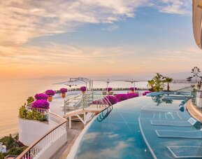 Outdoor pool with pool chairs at Grand Miramar All Luxury Suites & Residences.