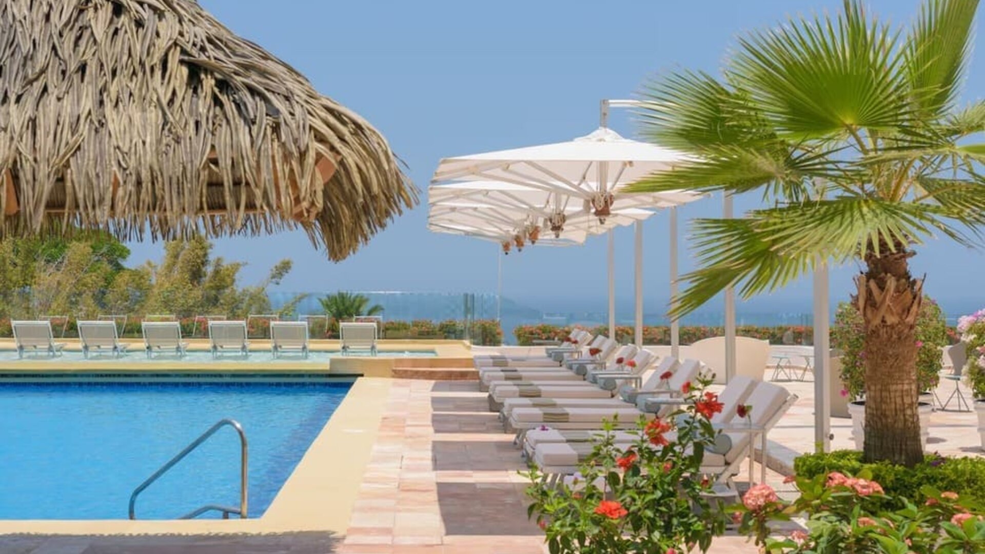 Outdoor pool and pool bar at Grand Miramar All Luxury Suites & Residences.