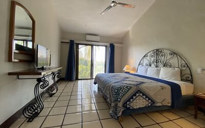 Romantic king room with natural light at Puerto De Luna Pet Friendly & Family Suites.