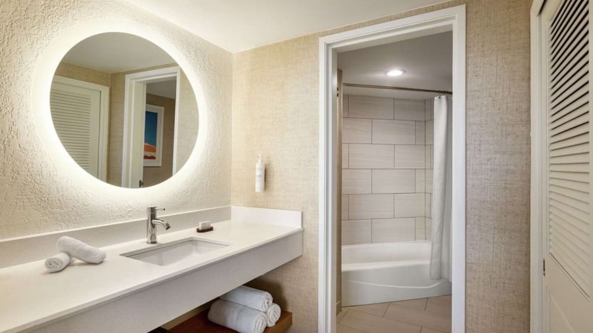 Guest bathroom with shower at Embassy Suites By Hilton Deerfield Beach Resort & Spa.