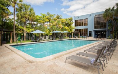 Outdoor pool with pool loungers at Regency Miami Airport By Sonesta.