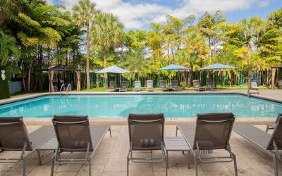 Outdoor pool with loungers at Regency Miami Airport By Sonesta.