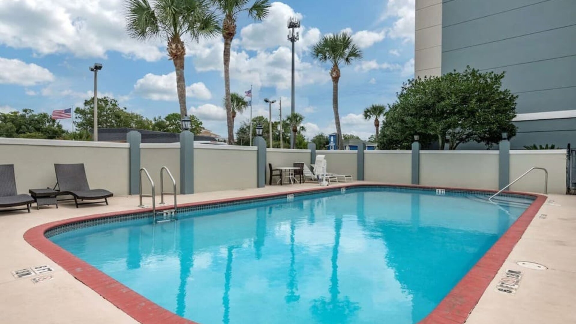 Outdoor pool with loungers at Comfort Suites Baymeadows Near Butler Blvd.