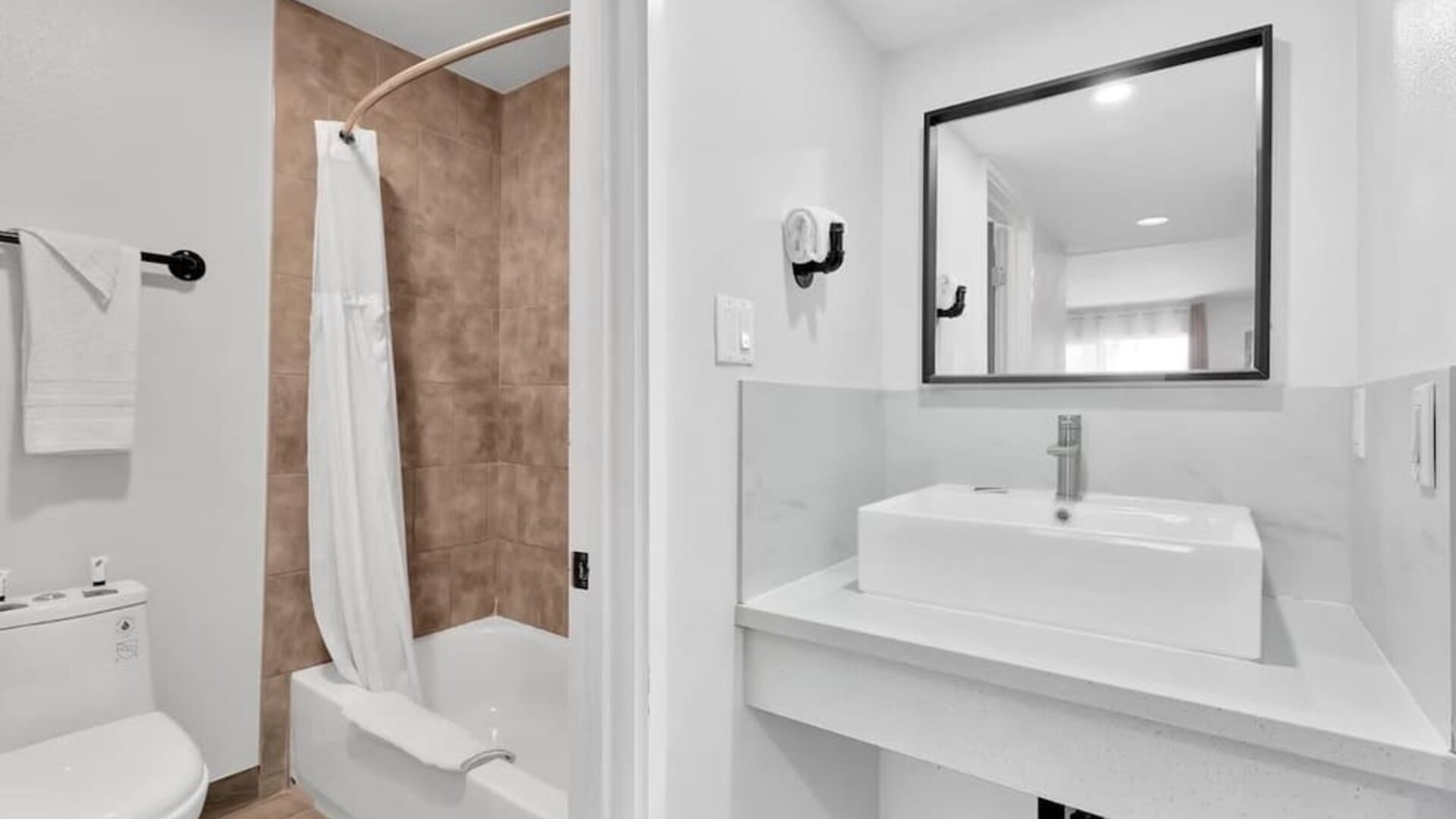 Guest bathroom with shower at Tradewinds Motel.