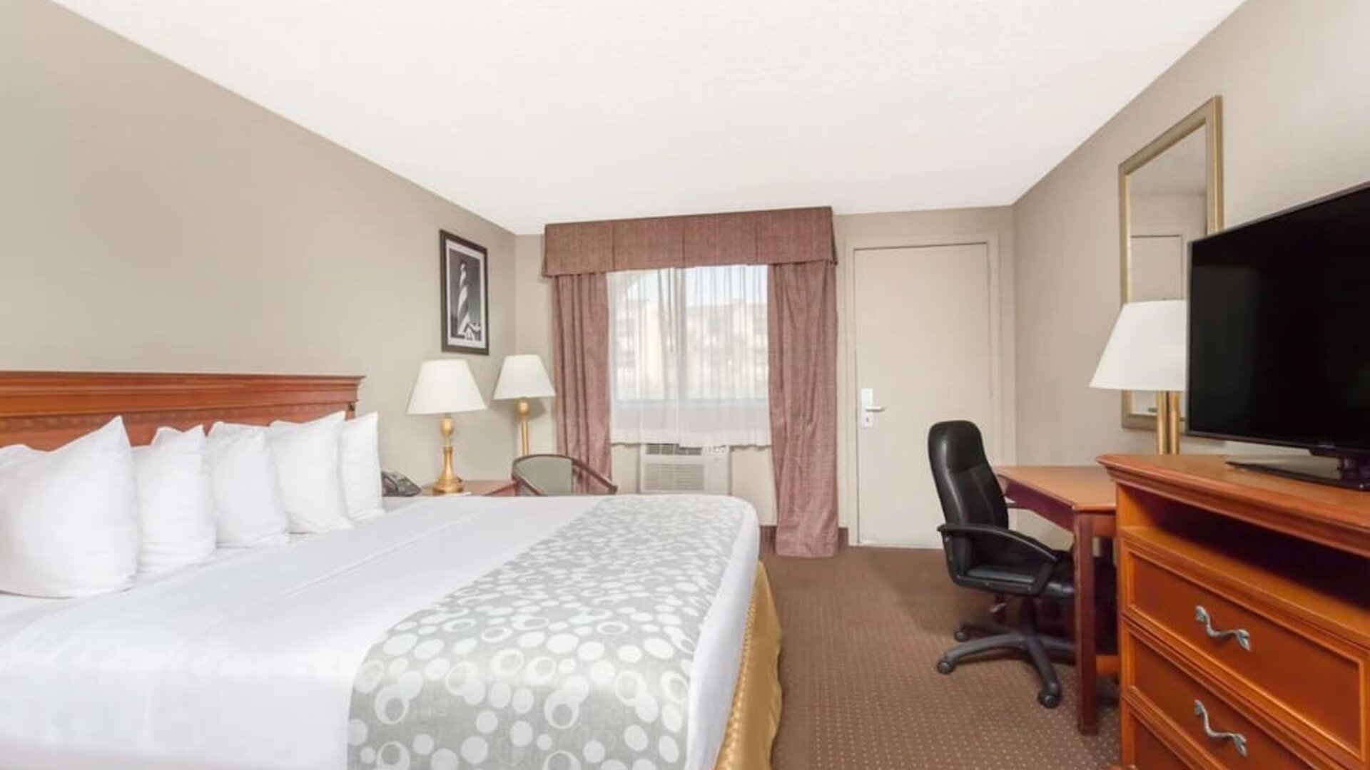 Day use room with TV and work desk at Days Inn By Wyndham St Augustine/Historic Downtown.