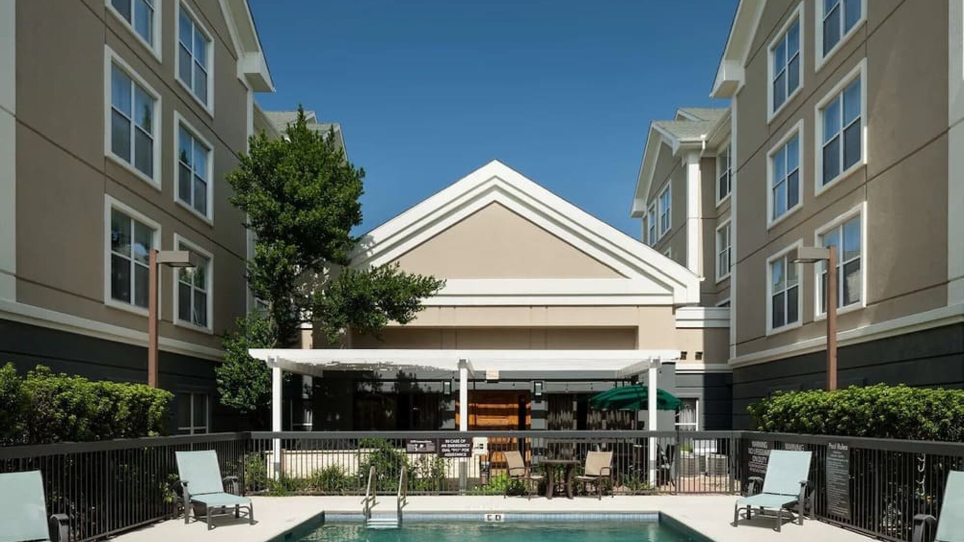 Outdoor pool with sun loungers at Homewood Suites By Hilton Austin NW Near The Domain.