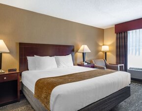 King room featuring premium bedding, bedside lighting, and a relaxing seating area at Best Western Braintree.