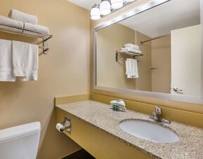 Modern guest bathroom featuring a granite vanity, large mirror, fresh towels, and complimentary toiletries at Best Western Braintree.