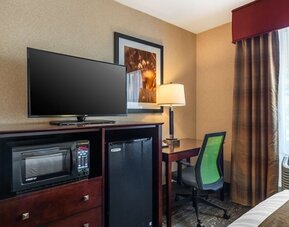 In-room workspace with desk, ergonomic chair, flat-screen TV, microwave, and mini refrigerator at Best Western Braintree.