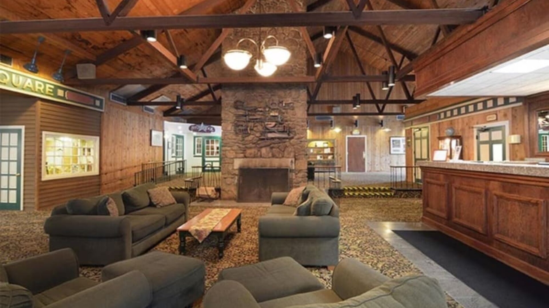 Welcoming lodge-style lounge with comfortable seating, fireplace, and rustic architectural details at Sturbridge Host Hotel.