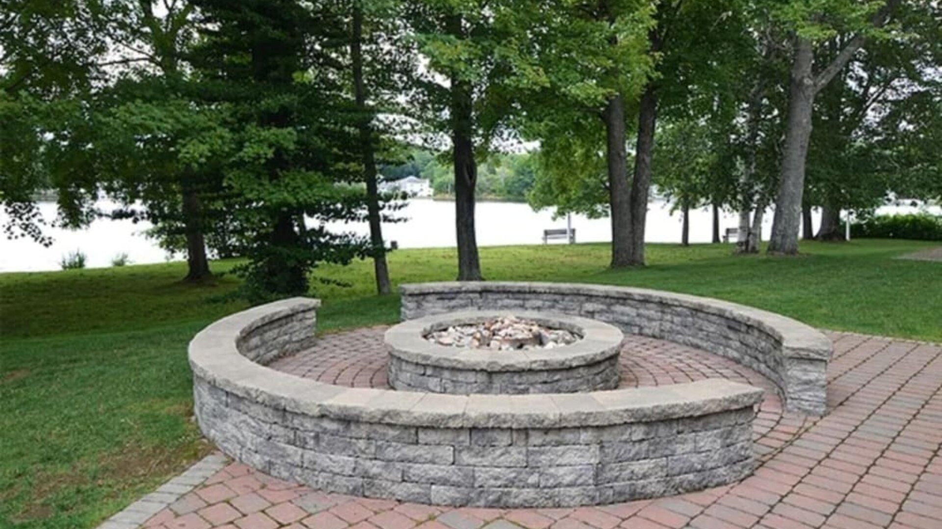 Outdoor fire pit area overlooking the waterfront, ideal for relaxing and social gatherings at Sturbridge Host Hotel.
