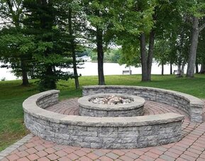 Outdoor fire pit area overlooking the waterfront, ideal for relaxing and social gatherings at Sturbridge Host Hotel.