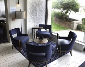Inviting lobby seating area with modern furnishings and natural light, perfect for relaxing or meeting with colleagues at Holiday Inn Express & Suites Boston-Cambridge.