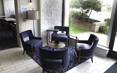 Inviting lobby seating area with modern furnishings and natural light, perfect for relaxing or meeting with colleagues at Holiday Inn Express & Suites Boston-Cambridge.
