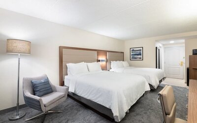 Double queen guest room featuring comfortable accommodations, contemporary furnishings, and ample space for families or groups at Holiday Inn Express & Suites Boston-Cambridge.
