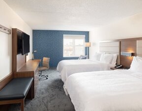 Double queen guest room with comfortable bedding, workspace, and contemporary décor designed for families and groups at Holiday Inn Express & Suites Boston-Cambridge.