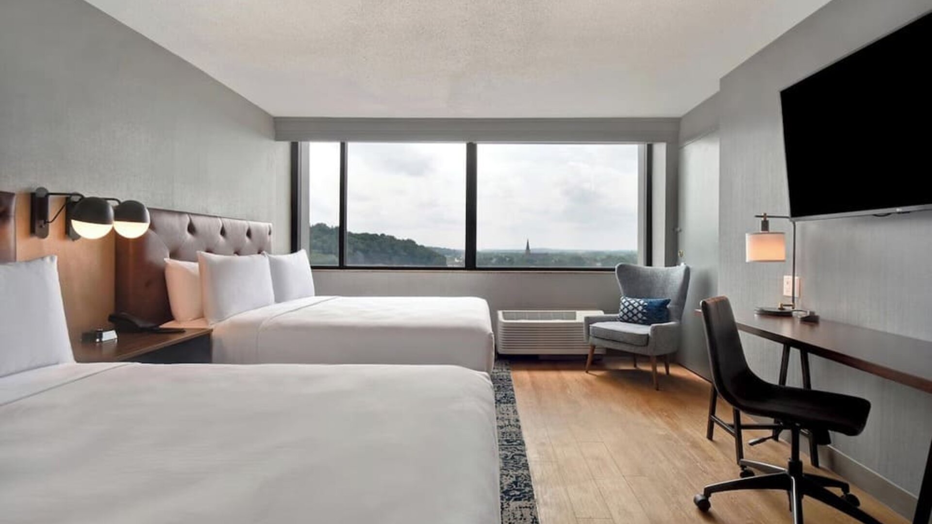 Double queen guest room featuring spacious accommodations, work desk, and scenic views for families, groups, or business travelers at Four Points by Sheraton Boston-Newton.