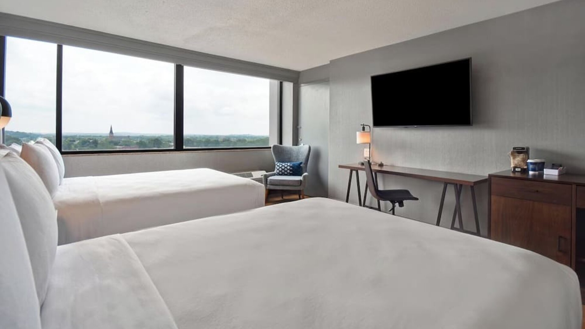 Double queen guest room offering comfortable accommodations, scenic views, and thoughtful amenities for families and groups at Four Points by Sheraton Boston-Newton.
