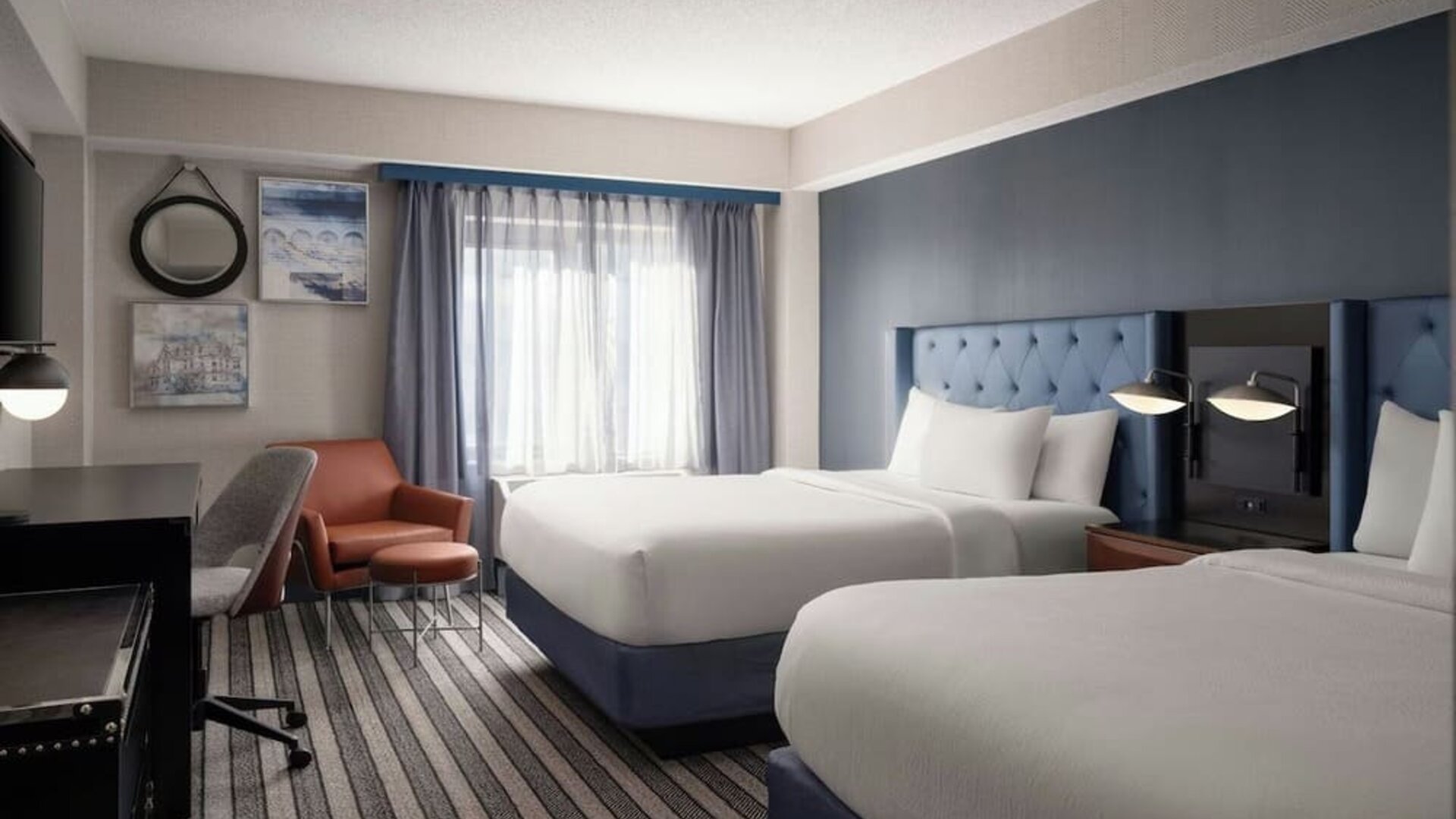 Double queen guest room offering comfortable accommodations, modern furnishings, and thoughtful amenities for families and groups at Courtyard by Marriott Boston Brookline.