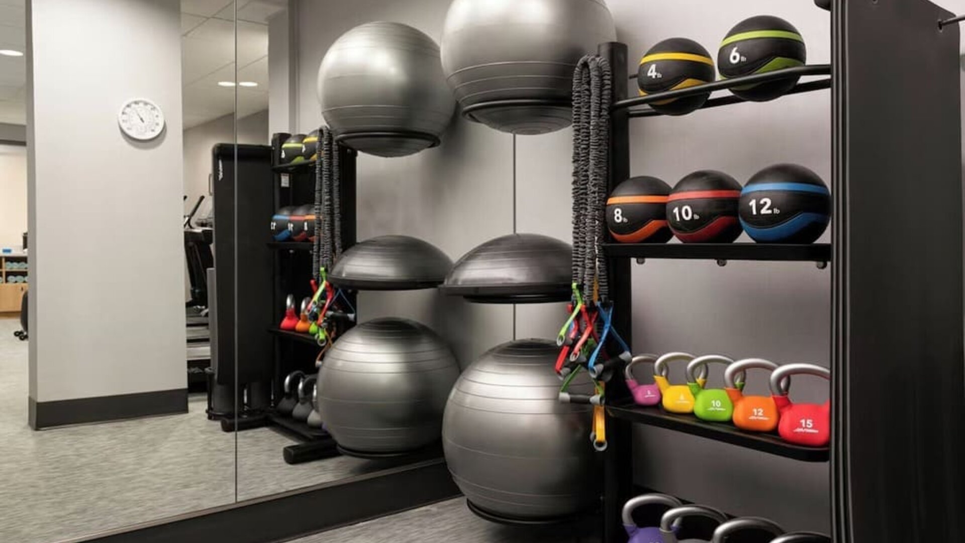 Fitness center featuring strength-training equipment, kettlebells, medicine balls, and functional fitness tools for a complete workout experience at Courtyard by Marriott Boston Brookline.