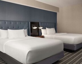 Double queen guest room featuring premium bedding, stylish furnishings, and comfortable accommodations for leisure or business travelers at Courtyard by Marriott Boston Brookline.