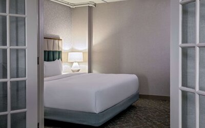 Private bedroom within a suite offering plush bedding, elegant furnishings, and a peaceful retreat for relaxation at DoubleTree by Hilton Westborough.