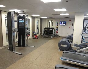 Fitness center equipped with cardio machines, free weights, and strength-training equipment to support guests’ wellness routines at DoubleTree by Hilton Westborough.
