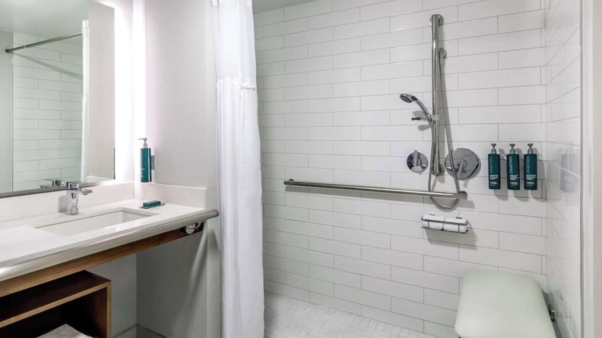 Accessible roll-in shower bathroom featuring safety features, spacious design, and modern amenities for enhanced guest comfort at DoubleTree by Hilton Westborough.