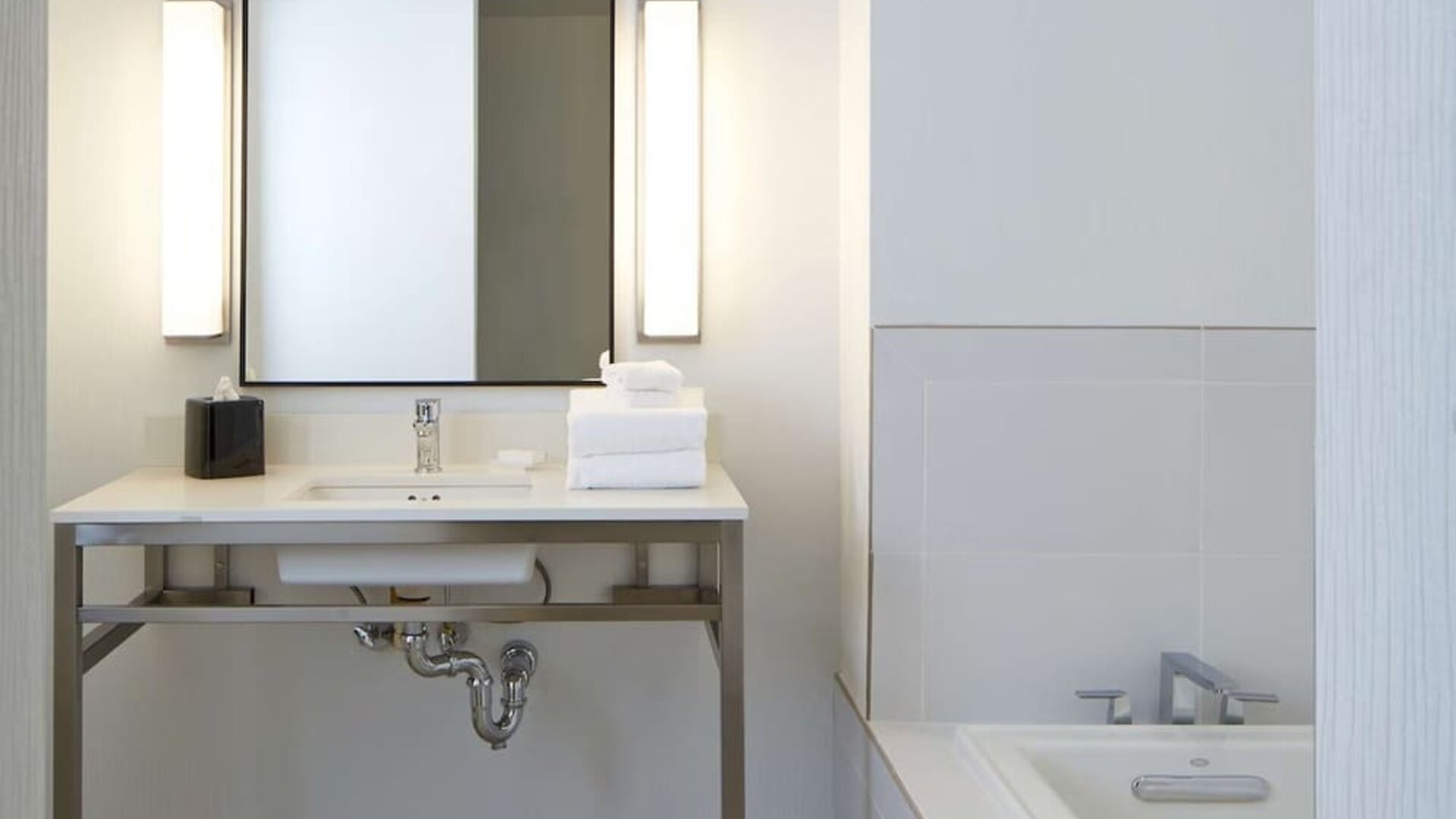 Spacious guest bathroom featuring a soaking tub, contemporary vanity, and bright modern finishes designed for relaxation at Hilton Garden Inn Boston/Marlborough.