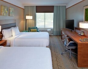 Guest room with two comfortable beds, spacious work area, and modern amenities designed for families, groups, and business travelers at Hilton Garden Inn Boston/Marlborough.