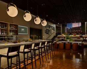 Stylish bar area offering handcrafted cocktails, modern seating, and a vibrant social atmosphere in the heart of Row NYC.