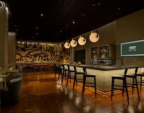 Modern hotel bar featuring stylish seating, premium beverage selections, and an energetic atmosphere perfect for evening gatherings at Row NYC.
