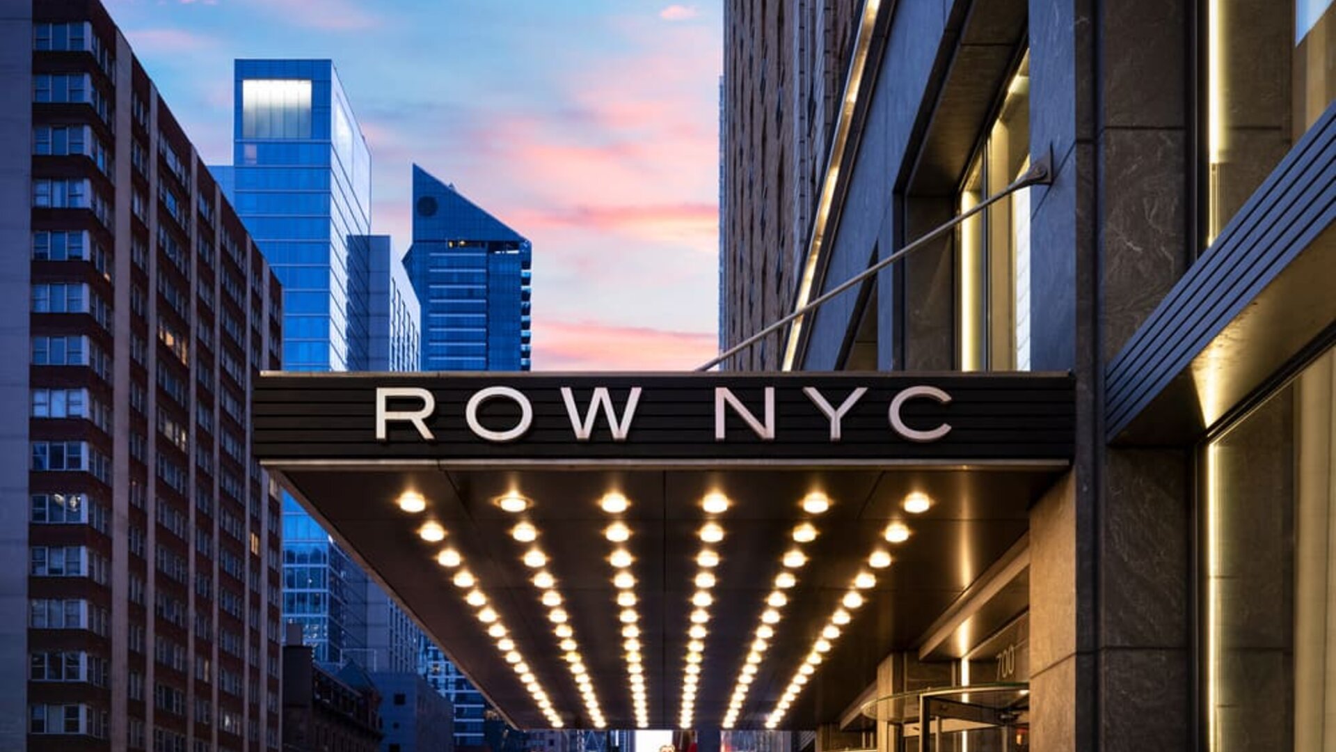 Entrance canopy of Row NYC illuminated with signature lighting, creating a memorable arrival experience in Times Square.