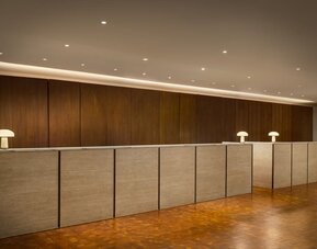 Modern reception desk featuring streamlined check-in services, contemporary design, and a welcoming atmosphere for guests arriving at Row NYC.