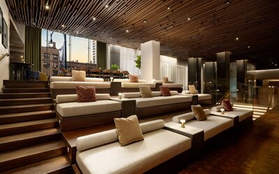 Tiered lounge seating area featuring modern furnishings, warm lighting, and inviting communal spaces for guests to relax and socialize at Row NYC.