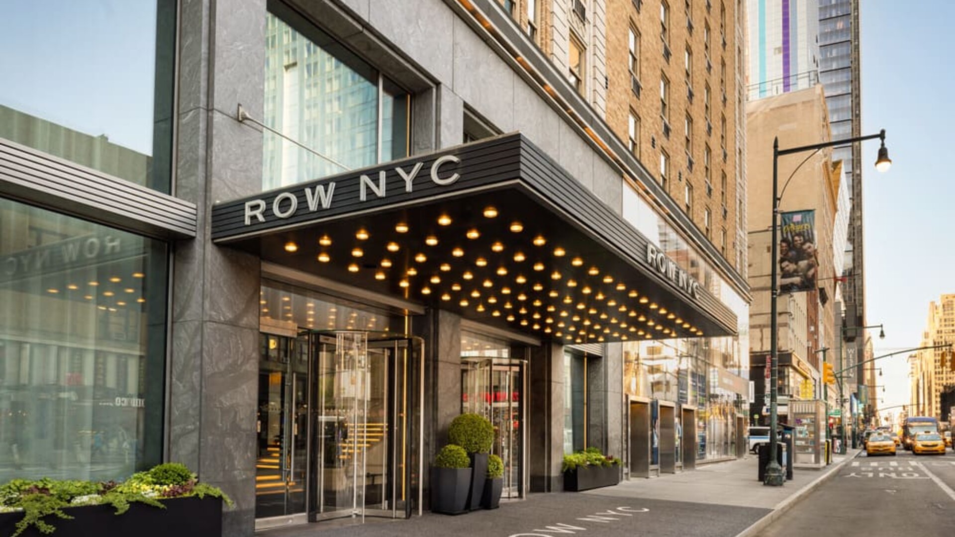 Street-level entrance of Row NYC featuring signature marquee lighting, modern architecture, and a welcoming arrival experience in New York City.