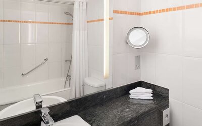 Guest bathroom with shower at Hilton London Kensington.
